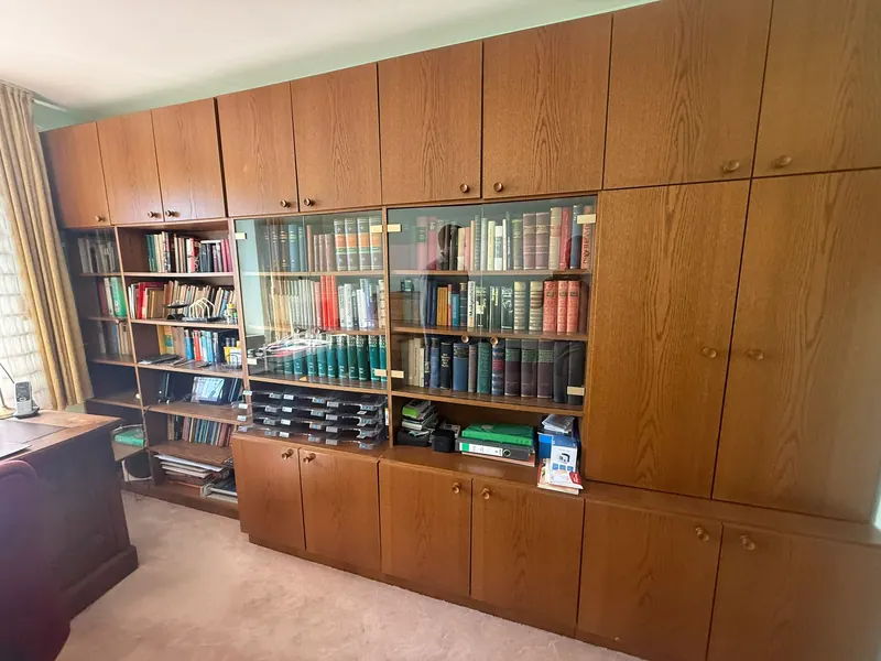 Estantería con libros y muebles antes del vaciado de pisos en Las Palmas