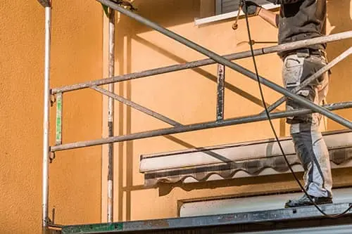 Trabajador en andamio durante reforma de fachada exterior en Las Palmas de Gran Canaria — Sosa Reformas y Vaciados